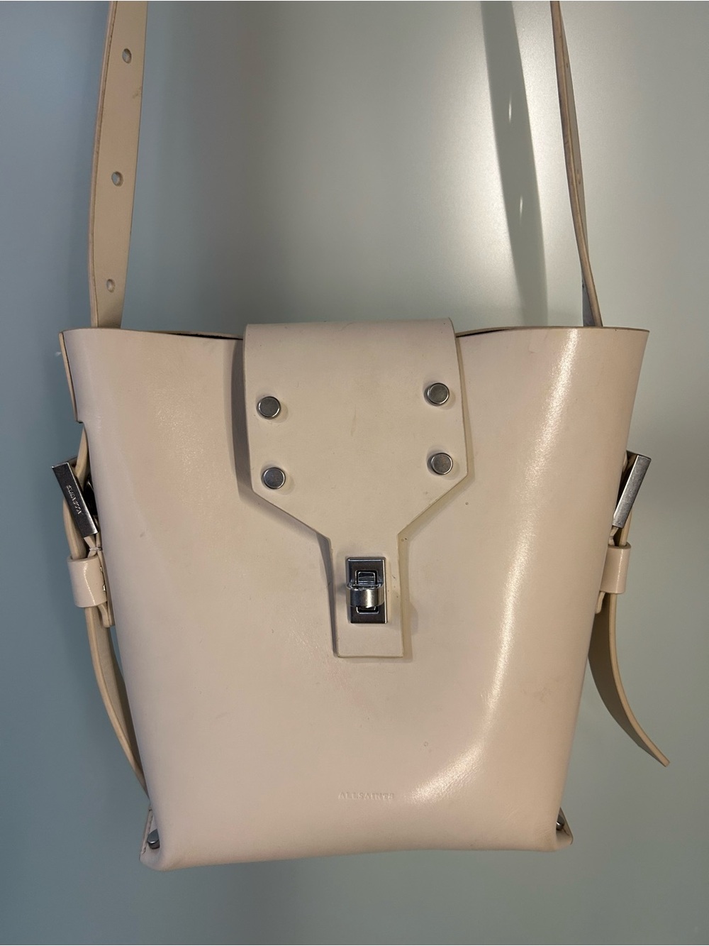 AllSaints Miro Turn Lock Leather Crossbody Bag Cream Silver Bucket